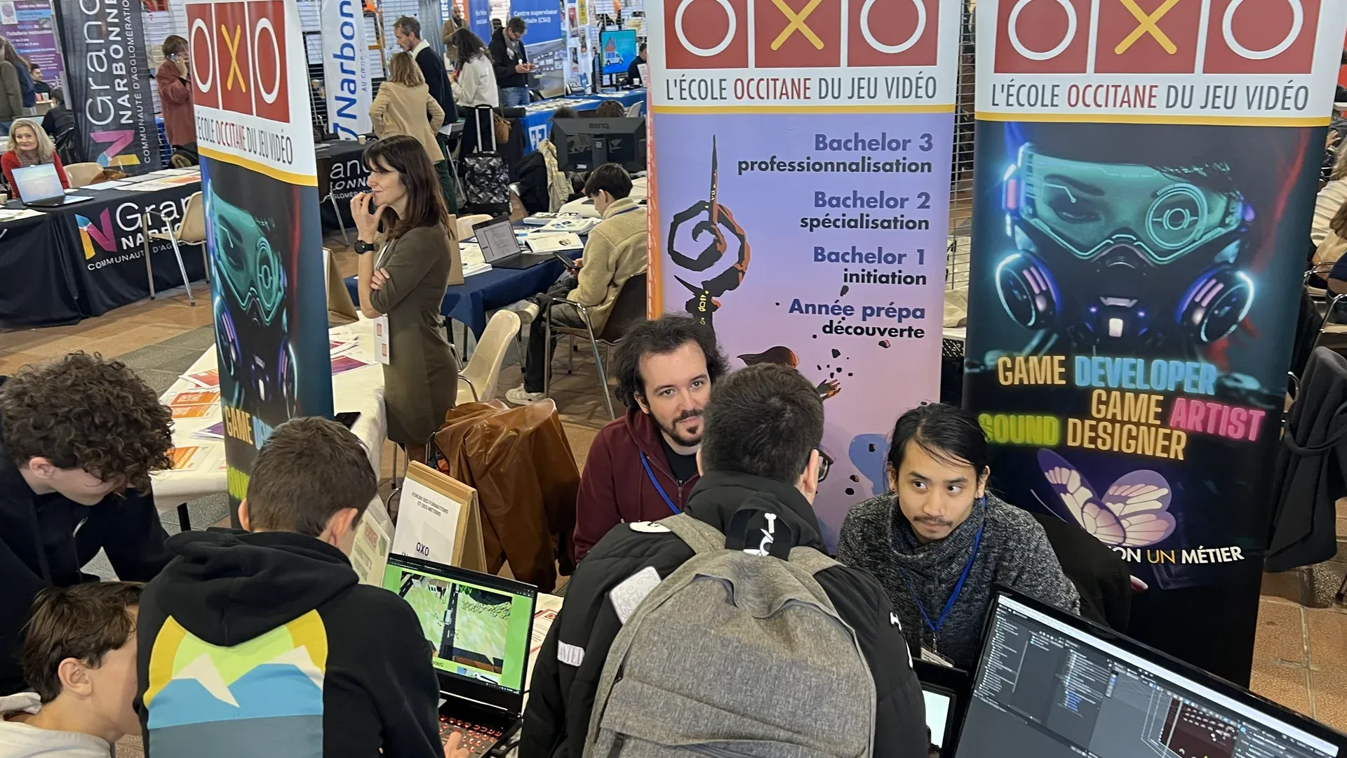 Des futurs étudiants se renseignent au stand d'OXO sur un salon